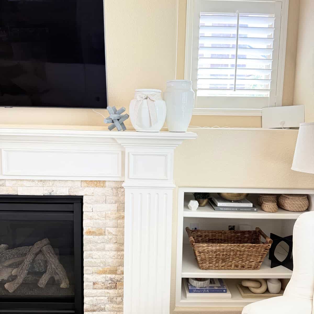 two white terracotta vases styled on a fireplace mantel