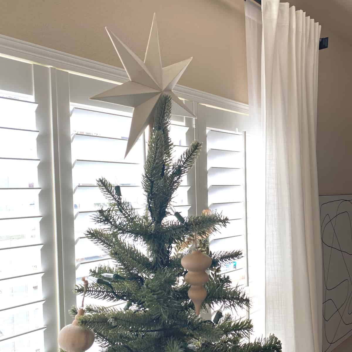 White wood star tops the Christmas tree